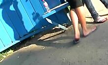 दो कचरा-दिखने वाली गर्लफ्रेंड बस स्टॉप पर अपनी गांड दिखा रही हैं।
